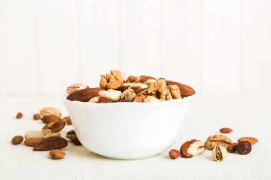 mixed nuts in bowl. Mix of various nuts on colored background. pistachios, cashews, walnuts, hazelnuts, peanuts and brazil nuts.