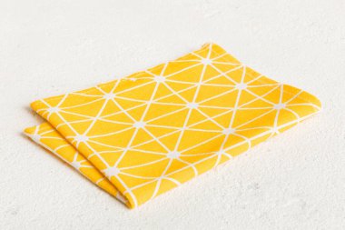 top view with yellow empty kitchen napkin isolated on table background. Folded cloth for mockup with copy space, Flat lay. Minimal style.