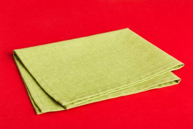 top view with green kitchen napkin isolated on table background. Folded cloth for mockup with copy space, Flat lay. Minimal style.