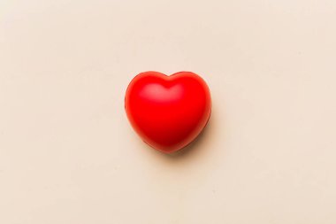 red heart shape on colored background. minimal concept top view with copy space.