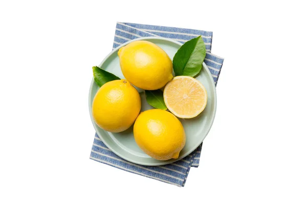 Frisch Geschnittene Zitrone Und Ganze Zitronen Auf Rundem Teller Isoliert — Stockfoto