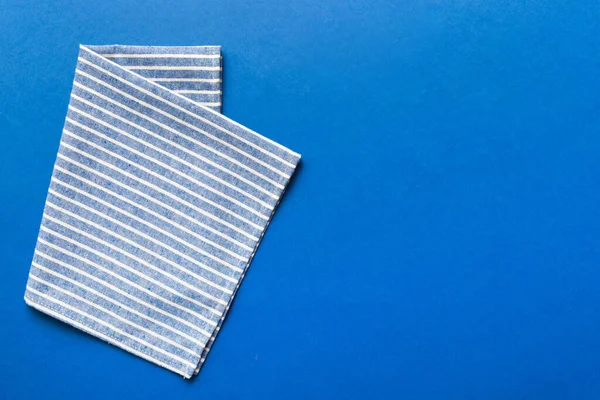 top view with blue kitchen napkin isolated on table background. Folded cloth for mockup with copy space, Flat lay. Minimal style.