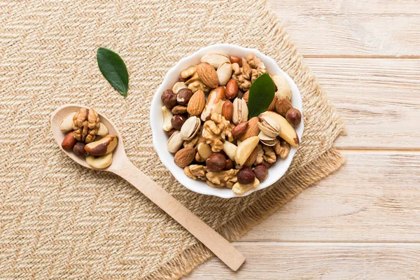 mixed nuts in bowl. Mix of various nuts on colored background. pistachios, cashews, walnuts, hazelnuts, peanuts and brazil nuts.