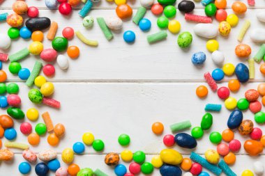 Renkli arka planda karışık renkli şeker koleksiyonu. Düz yerde, üst tarafta. Renkli çikolata kaplı şeker çerçevesi.