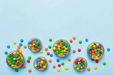 farklı renkte yuvarlak şekerler ve kavanozlar. Fotokopi alanı olan büyük çeşitlilikteki şeker ve şekerlerin üst görünümü.