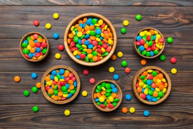 farklı renkte yuvarlak şekerler ve kavanozlar. Fotokopi alanı olan büyük çeşitlilikteki şeker ve şekerlerin üst görünümü.