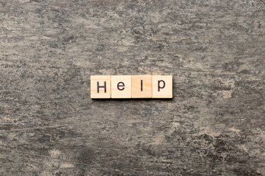 Tahta bloğa yazılmış yardım kelimesi. Tablo, konsept üzerinde yardım metni.