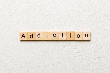 Tahta blokta yazan bağımlılık kelimesi. Masada bağımlılık metni, konsept.