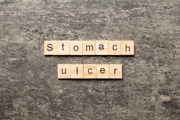 stomach ulcer word written on wood block. stomach ulcer text on table, concept.
