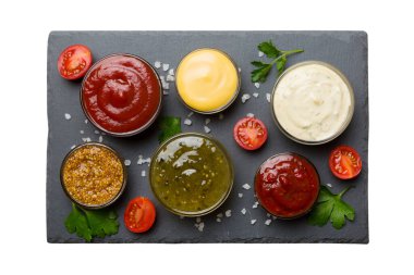 Masada bir sürü farklı sos ve bitki vardı, düz bir manzarası vardı. Tabakta soslar, sağlıklı konsept..