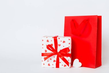 Shopping bag with gift box on colored background perspecrive view. Space for text holiday concept.