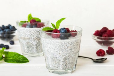 Sağlıklı kahvaltı ya da sabah chia tohumlu vanilyalı puding ahududu ve böğürtlen, vejetaryen gıda, diyet ve sağlık konsepti. Ahududu ve yabanmersinli Chia pudingi..