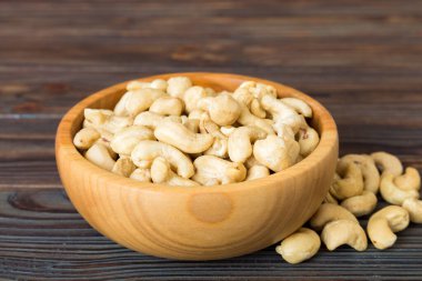 cashew nuts in wooden bowl on table background. top view. Space for text. Healthy food