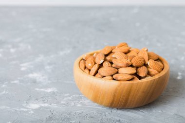 Fresh healthy Almond in bowl on colored table background. Top view.