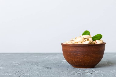 Fresh healthy Pistachios in bowl on colored table background. Top view. Healthy eating concept. Super foods.