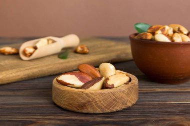 Fresh healthy Brazil nuts in bowl on colored table background. Top view Healthy eating bertholletia concept. Super foods.