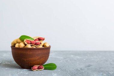 Fresh healthy peanuts in bowl on colored table background. Top view Healthy eating bertholletia concept. Super foods.