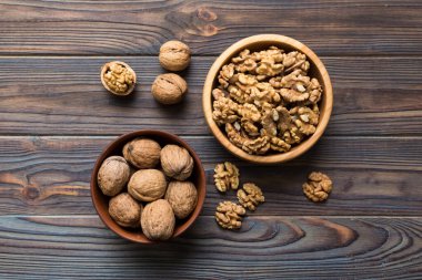 Fresh healthy walnuts in bowl on colored table background. Top view Healthy eating bertholletia concept. Super foods.