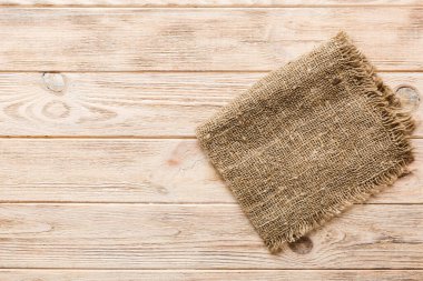 Old burlap fabric napkin, sackcloth on table background. top view with copy space.