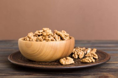 Fresh healthy walnuts in bowl on colored table background. Top view Healthy eating bertholletia concept. Super foods.