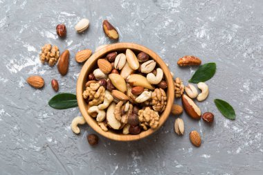 mixed nuts in bowl. Mix of various nuts on colored background. pistachios, cashews, walnuts, hazelnuts, peanuts and brazil nuts.