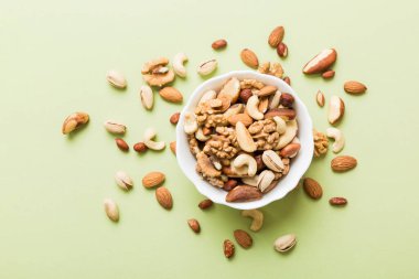 mixed nuts in bowl. Mix of various nuts on colored background. pistachios, cashews, walnuts, hazelnuts, peanuts and brazil nuts.