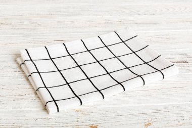 top view with white empty kitchen napkin isolated on table background. Folded cloth for mockup with copy space, Flat lay. Minimal style.