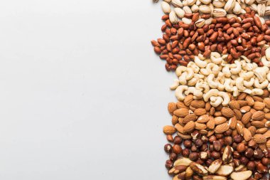 different nuts frame background. Close up, top view, flat lay with vopy space. Walnut, pistachios, almonds, hazelnuts and cashews.