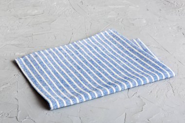 top view with blue kitchen napkin isolated on table background. Folded cloth for mockup with copy space, Flat lay. Minimal style.