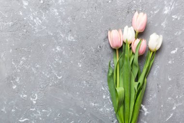 Renkli masa arkasında bir buket pembe lale. Kopyalama alanı olan üst görünüm. Baharı bekliyorum. Mutlu Paskalyalar. Düz yatıyordu.