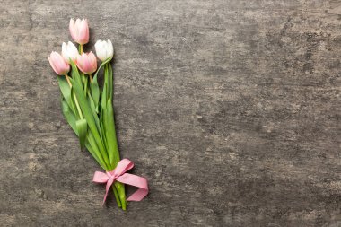 Renkli masa arkasında bir buket pembe lale. Kopyalama alanı olan üst görünüm. Baharı bekliyorum. Mutlu Paskalyalar. Düz yatıyordu.