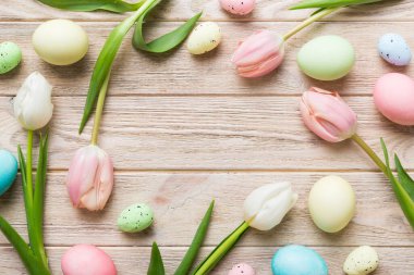 Mutlu Paskalya kompozisyonu. Renkli masada sarı laleli Paskalya yumurtaları. Doğal boyalı renkli yumurtalar arkaplan arkaplan görünümü kopya alanı ile.