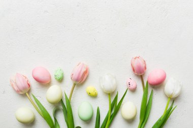 Mutlu Paskalya kompozisyonu. Renkli masada sarı laleli Paskalya yumurtaları. Doğal boyalı renkli yumurtalar arkaplan arkaplan görünümü kopya alanı ile.