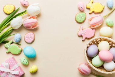 Yumurtalı Paskalya çerçevesi, renkli bir arka planda hediye kutusu ve lale. Minimum konsept. Üst Manzara Mutlu Paskalyalar kompozisyonu. Metin için yerin bir kopyasına sahip kart.