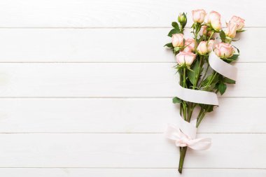 Renkli arka planda pembe buket ve beyaz güller. Anneler günü, sevgililer günü, doğum günü kutlaması konsepti. Tebrik kartı. Metin için boşluk kopyala, üst görünüm.