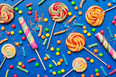 Lezzetli İştah açıcı Parti Aksesuarları Mutlu Yıllar Tatlı. Renkli arkaplanda farklı tipte şekerler, kopyalama alanı. Renkli doğum günü partisi geçmişi.