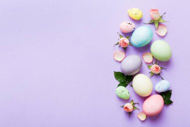 Mutlu Paskalyalar. Renkli masada sarı güllü Paskalya yumurtaları. Doğal boyalı renkli yumurtalar arkaplan arkaplan görünümü kopya alanı ile.