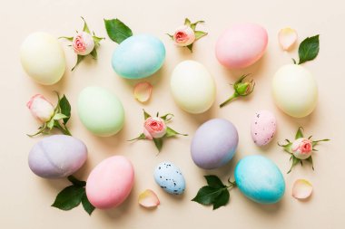 Mutlu Paskalyalar. Renkli masada sarı güllü Paskalya yumurtaları. Doğal boyalı renkli yumurtalar arkaplan arkaplan görünümü kopya alanı ile.