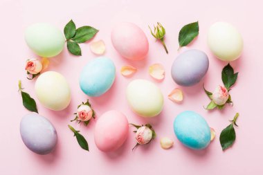 Mutlu Paskalyalar. Renkli masada sarı güllü Paskalya yumurtaları. Doğal boyalı renkli yumurtalar arkaplan arkaplan görünümü kopya alanı ile.