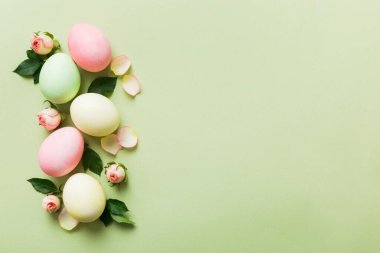 Mutlu Paskalyalar. Renkli masada sarı güllü Paskalya yumurtaları. Doğal boyalı renkli yumurtalar arkaplan arkaplan görünümü kopya alanı ile.