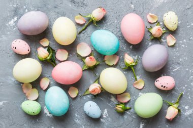 Mutlu Paskalyalar. Renkli masada sarı güllü Paskalya yumurtaları. Doğal boyalı renkli yumurtalar arkaplan arkaplan görünümü kopya alanı ile.