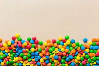Renkli arka planda karışık renkli şeker koleksiyonu. Düz yerde, üst tarafta. Renkli çikolata kaplı şeker çerçevesi.