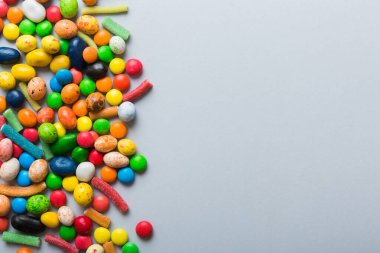 Renkli arka planda karışık renkli şeker koleksiyonu. Düz yerde, üst tarafta. Renkli çikolata kaplı şeker çerçevesi.