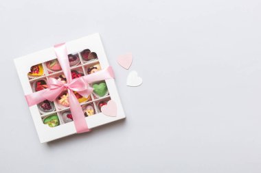 Valentine day composition: sweet candy, with gift boxes with bow and red felt hearts, photo template, background. Top View with copy space.