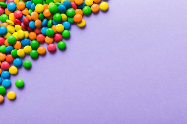 Renkli arka planda karışık renkli şeker koleksiyonu. Düz yerde, üst tarafta. Renkli çikolata kaplı şeker çerçevesi.