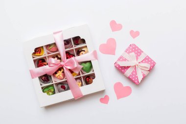 Valentine day composition: sweet candy, with gift boxes with bow and red felt hearts, photo template, background. Top View with copy space.