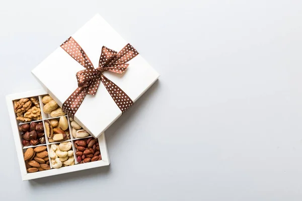 stock image Various varieties of nuts lying in paper box on table background. Top view. Healthy food. Close up, copy space, top view, flat lay. Walnut, pistachios, almonds, hazelnuts and cashews.