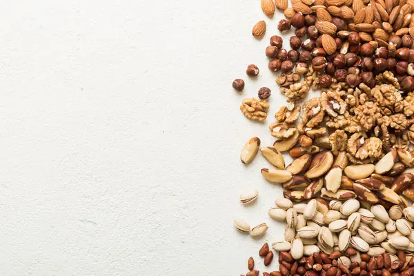 different nuts frame background. Close up, top view, flat lay with vopy space. Walnut, pistachios, almonds, hazelnuts and cashews.