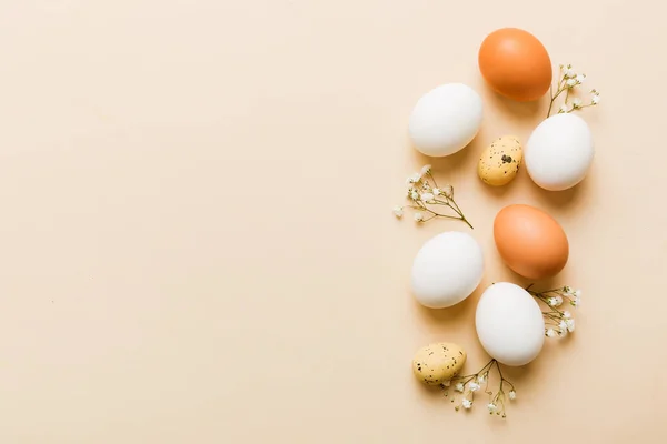 stock image Happy Easter composition. Easter eggs on colored table with gypsophila. Natural dyed colorful eggs background top view with copy space.