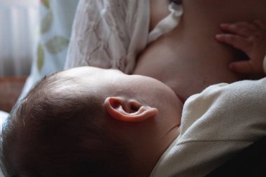 Genç bir kadın bebeğini emziriyor..